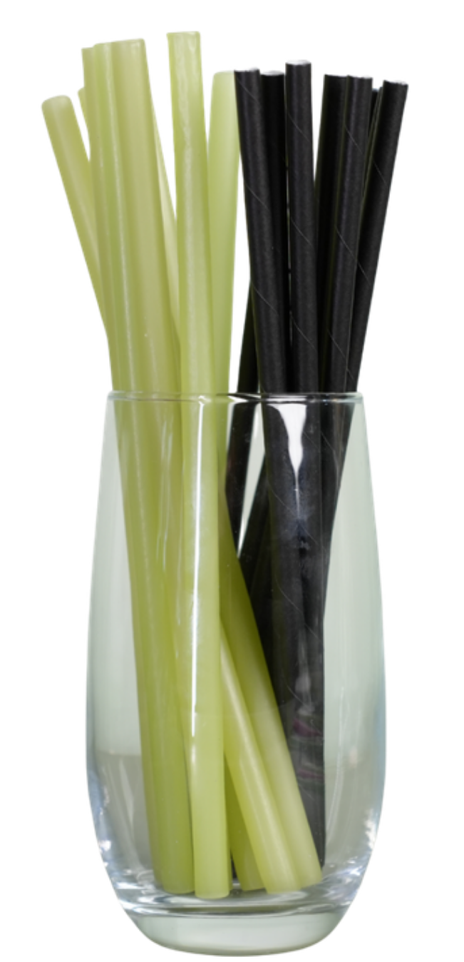 ADA plant-based straws beside conventional black plastic straws in a glass